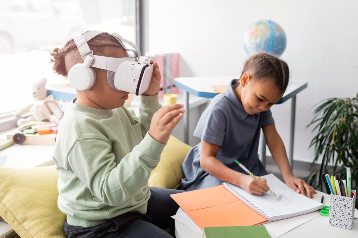 A child wearing a VR headset reacts excitedly, while another child sketches in a notebook, surrounded by colorful stationery and a globe.